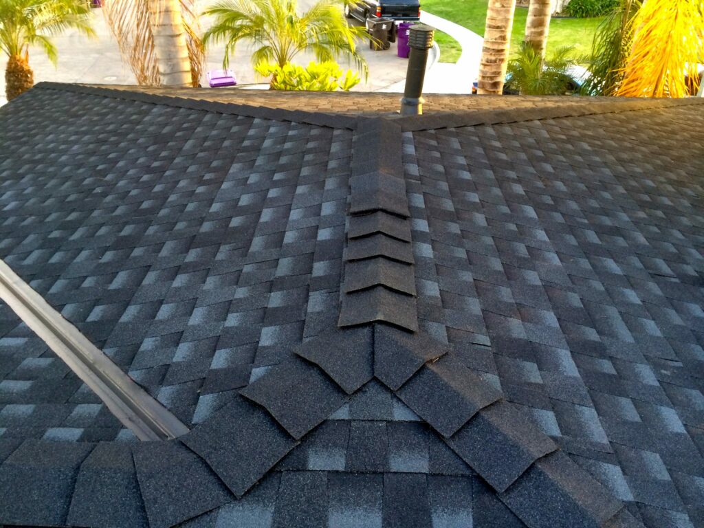 Roofer in Belmont Shores with nailgun installing Asphalt Shingles or Bitumen Tiles on a new house under construction