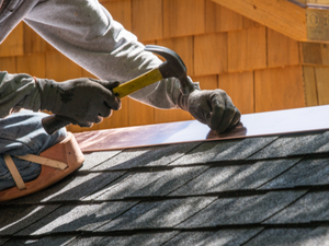 Cypress roofing contractor making repairs with new copper flashing .